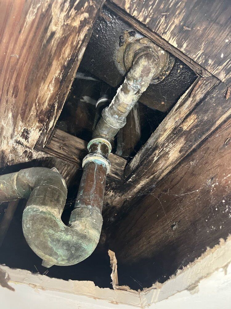 Corroded lines exposed through a ceiling opening