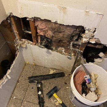 Wall opened to remove failed cast iron stack sections